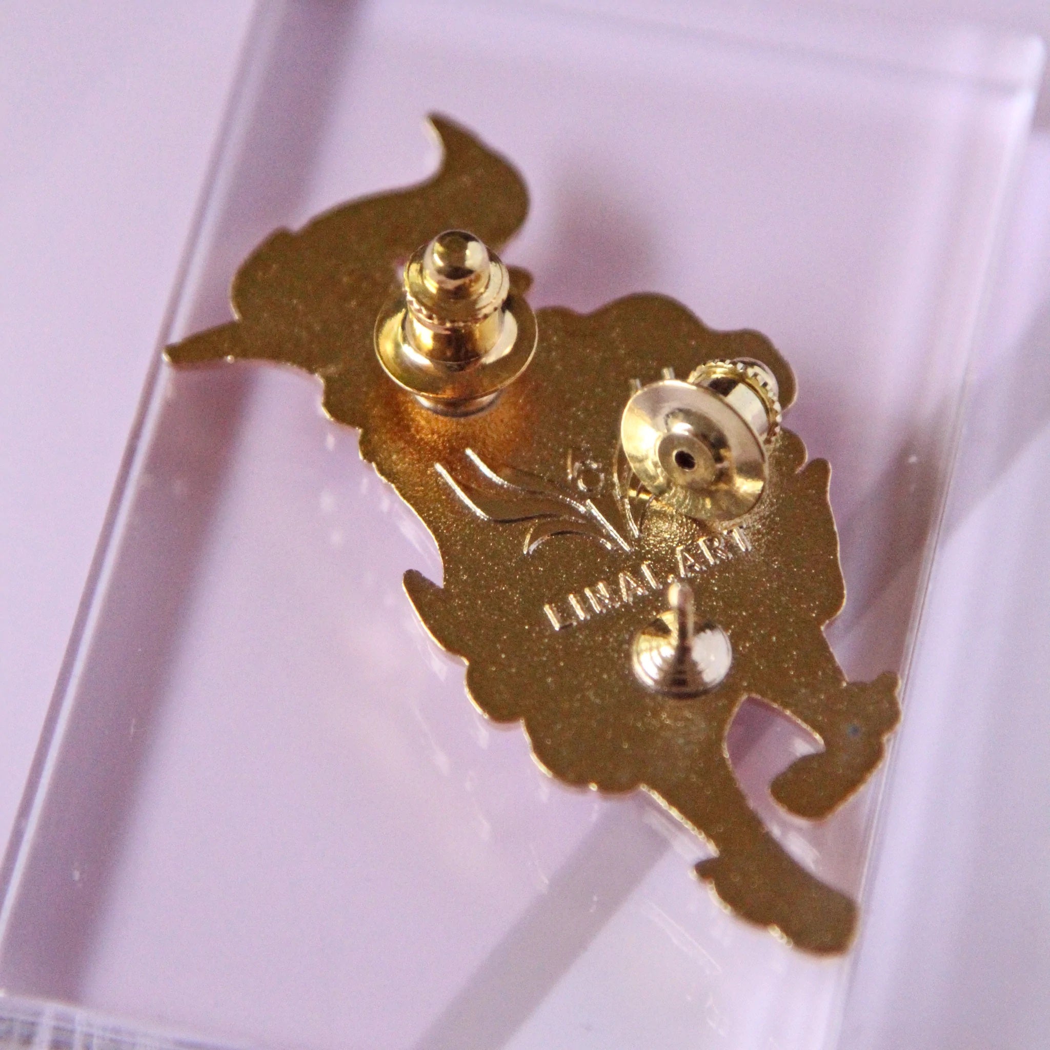 Enamel pin locking backs attached to an enamel pin